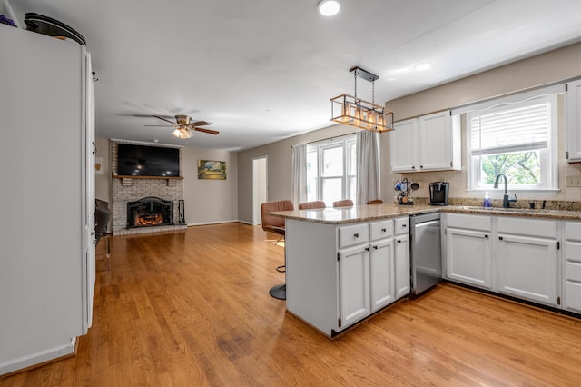 4805 Laurel Creek Cir, Lexington, KY 40515 - kitchen with a sink, dishwasher, a peninsula, a brick fireplace, and open floor plan