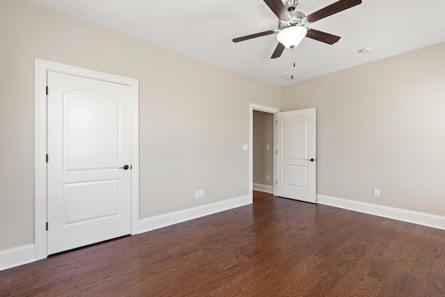 unfurnished bedroom with dark wood-style flooring, baseboards, and ceiling fan