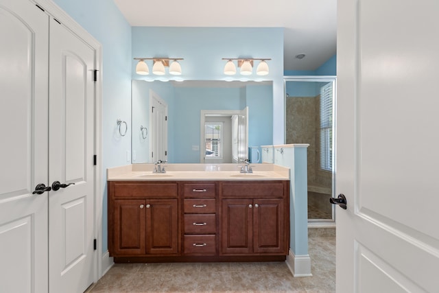 bathroom with double vanity, tile patterned floors, a shower stall, and a sink
