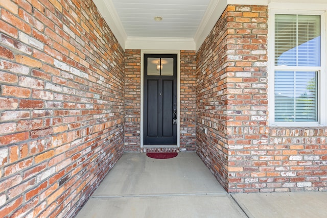 view of exterior entry featuring brick siding