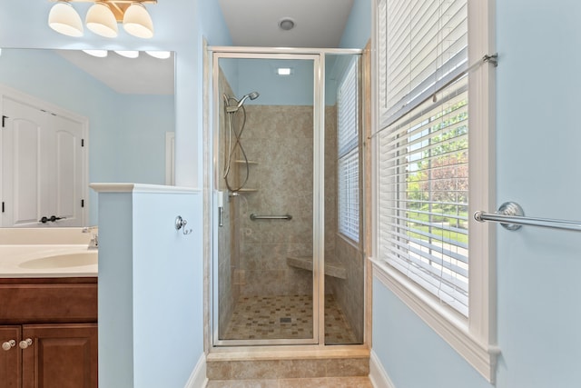 bathroom featuring vanity, baseboards, tile patterned flooring, and a stall shower