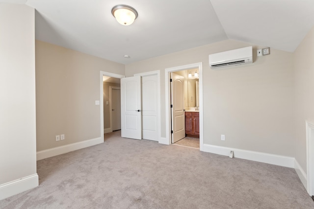 unfurnished bedroom featuring light colored carpet, a wall mounted air conditioner, and baseboards