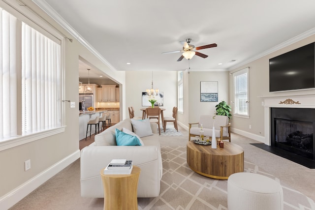 living area with ceiling fan, a fireplace with flush hearth, baseboards, ornamental molding, and light carpet