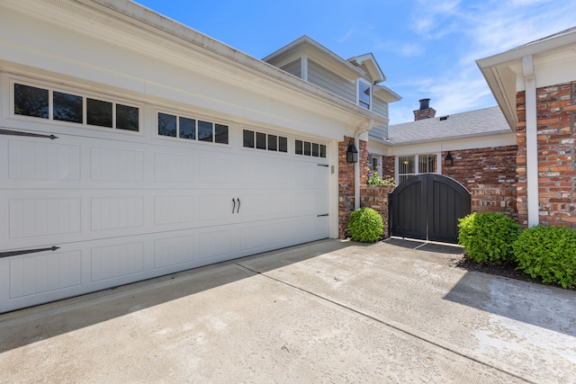 garage featuring a gate and concrete driveway