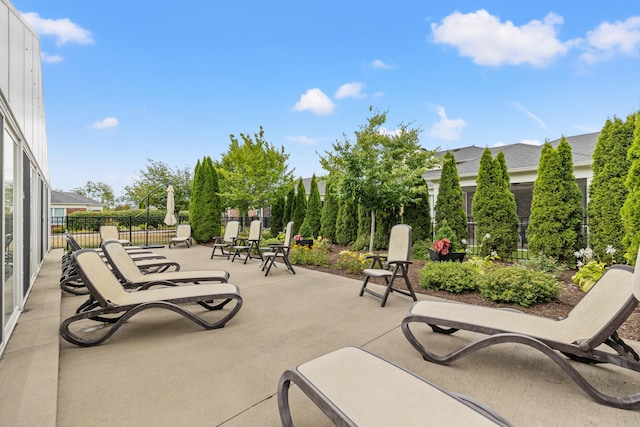 view of property's community with fence and a patio area