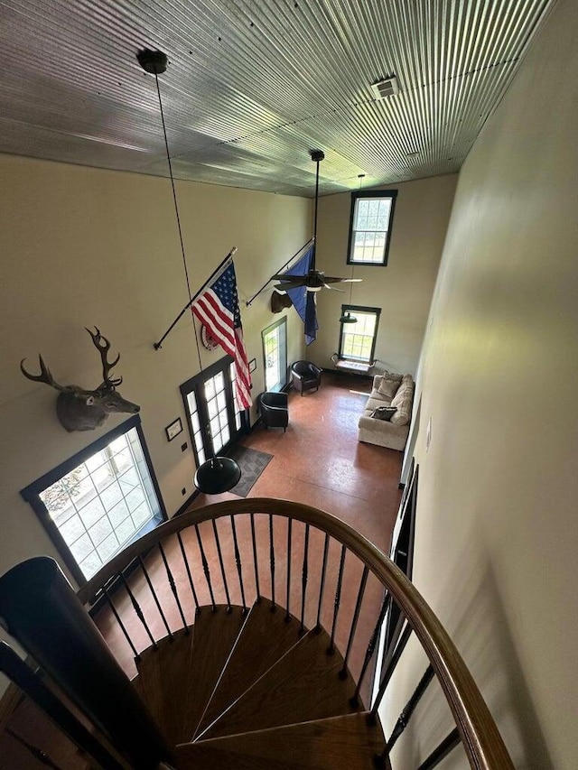 stairway with ceiling fan, french doors, visible vents, and a towering ceiling