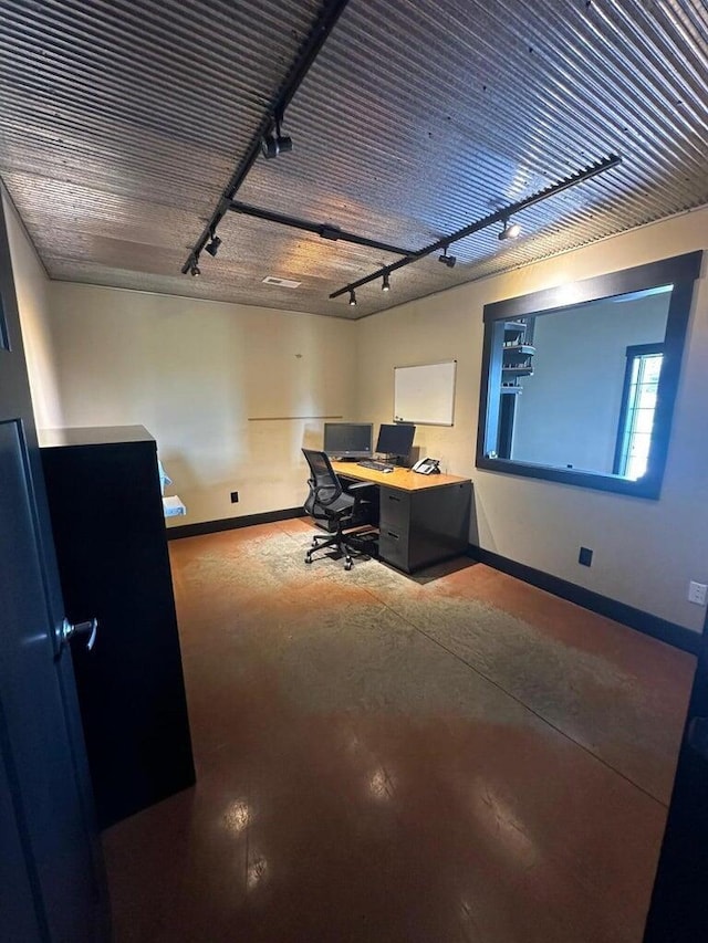 office space with concrete flooring, baseboards, and track lighting