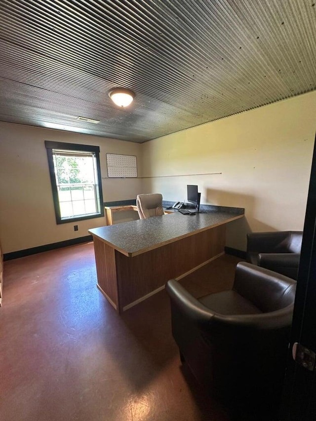 office space featuring baseboards and concrete floors