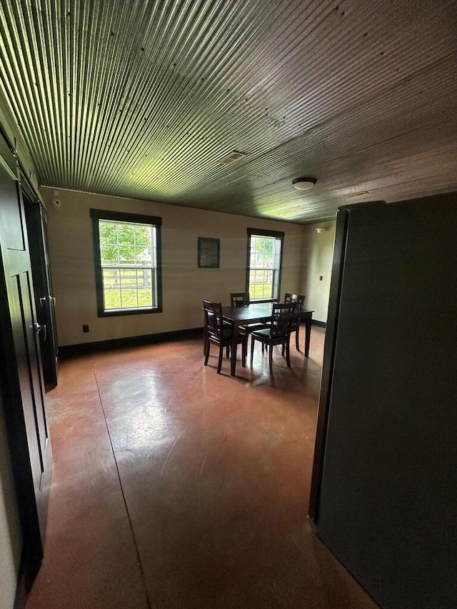 dining room featuring baseboards and finished concrete flooring