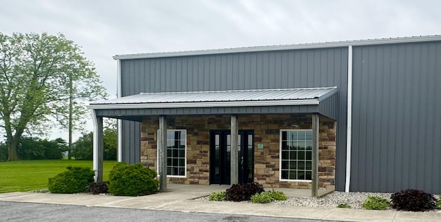 exterior space featuring a porch, metal roof, and stone siding