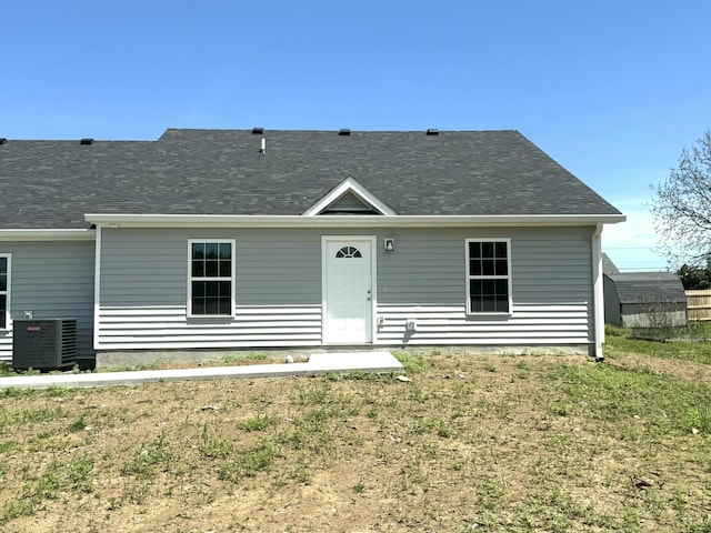 view of front of property with central AC unit and a front yard