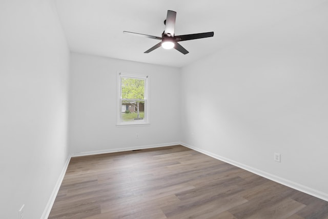 unfurnished room featuring wood finished floors, ceiling fan, and baseboards