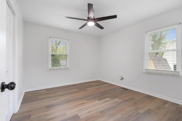 unfurnished room featuring wood finished floors, a ceiling fan, and baseboards
