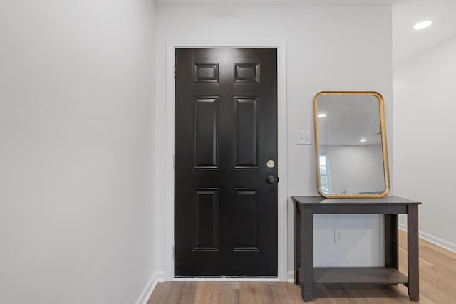entryway featuring wood finished floors, baseboards, and recessed lighting