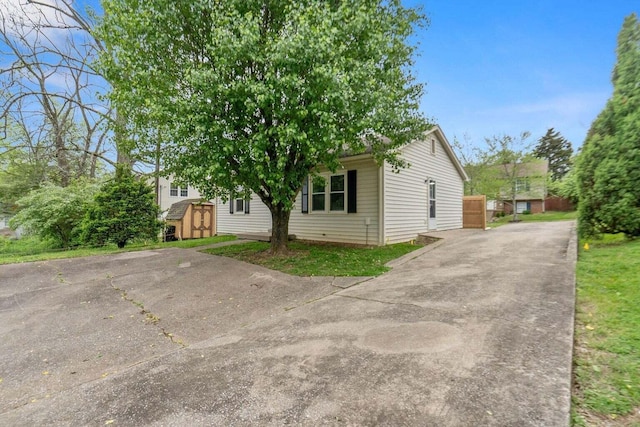 view of front facade with driveway and a storage shed