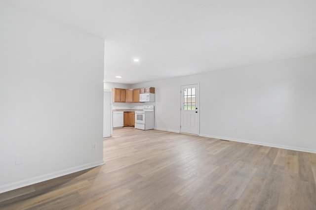 unfurnished living room featuring light wood-style flooring, baseboards, and recessed lighting