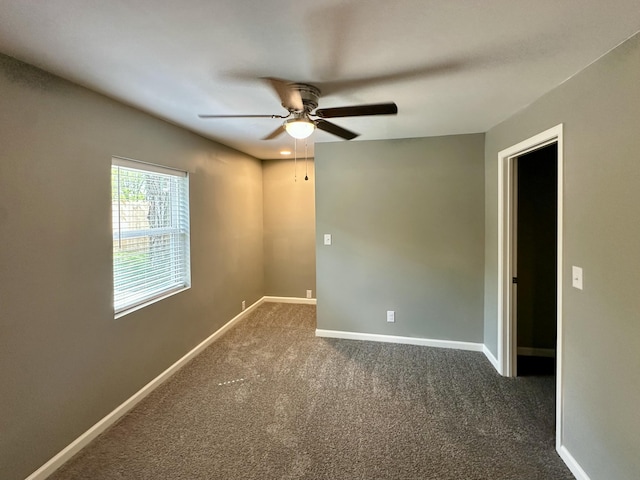 spare room with carpet floors, ceiling fan, and baseboards