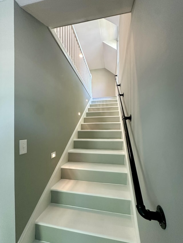 stairs featuring vaulted ceiling
