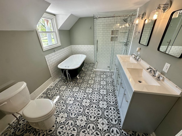 full bath featuring a sink, a shower stall, toilet, and a freestanding bath