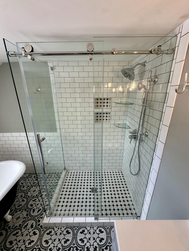bathroom with tile patterned flooring, a stall shower, and a soaking tub