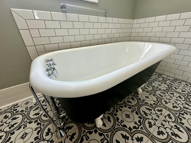full bath featuring a freestanding tub and tile patterned floors
