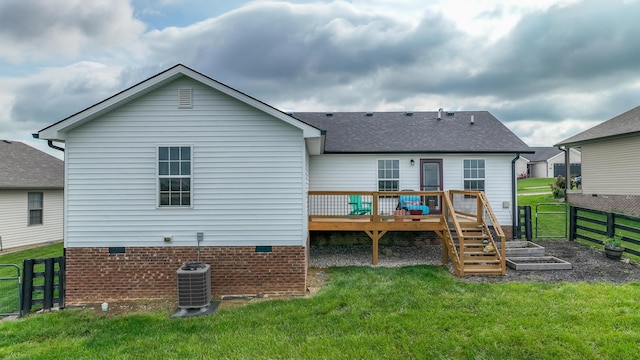 rear view of property with fence, a wooden deck, a shingled roof, central air condition unit, and a yard