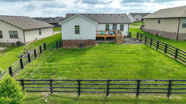 back of property featuring a fenced backyard, a wooden deck, a yard, and central air condition unit
