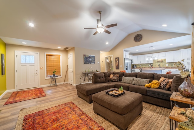 living area with light wood-style floors, ceiling fan, recessed lighting, and lofted ceiling
