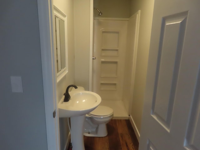 full bathroom with toilet, baseboards, wood finished floors, and a stall shower