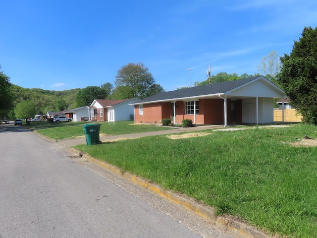 ranch-style house featuring brick siding, a front lawn, and fence