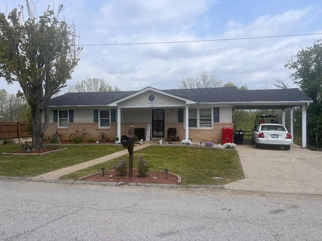 single story home with concrete driveway, an attached carport, a front lawn, and brick siding
