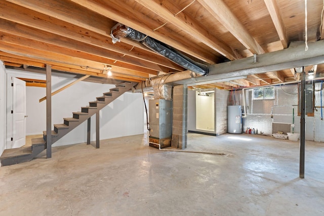 below grade area with heating unit, water heater, electric panel, and stairway