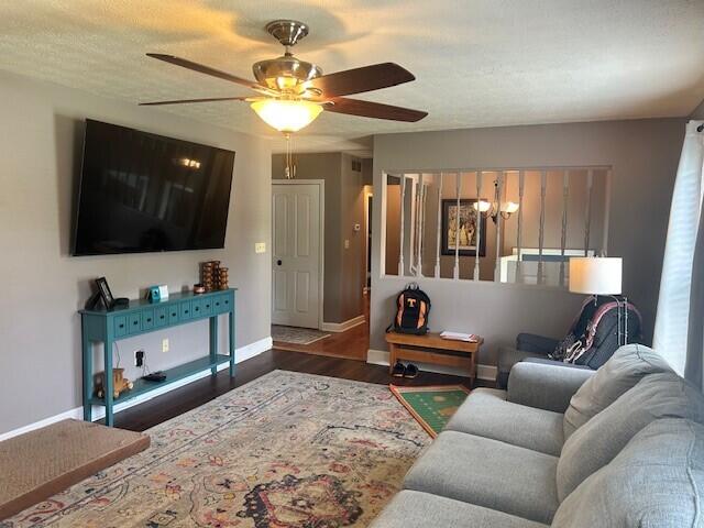 living room featuring baseboards, a ceiling fan, and wood finished floors