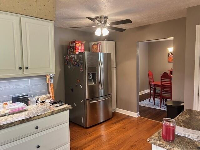kitchen featuring white cabinets, ceiling fan, stainless steel fridge, a textured ceiling, and wood finished floors