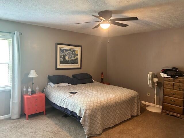 bedroom featuring carpet, a textured ceiling, and ceiling fan