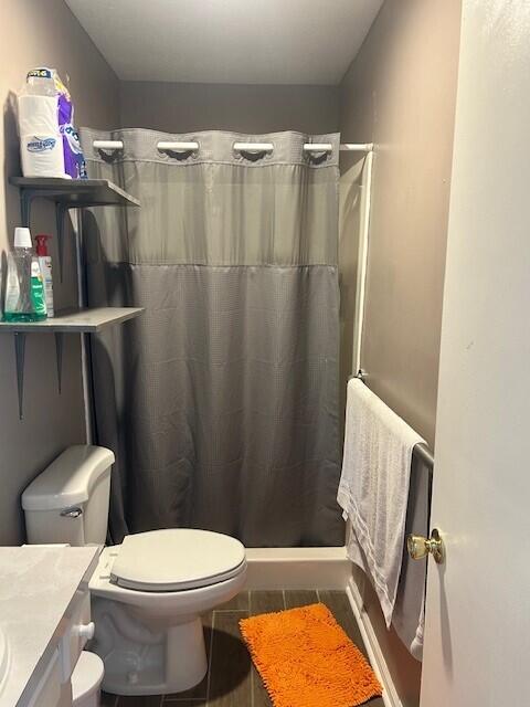 bathroom featuring vanity, toilet, and a stall shower