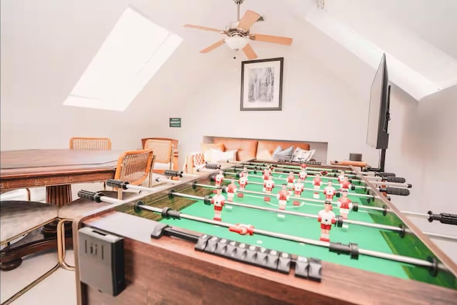 rec room with a ceiling fan and vaulted ceiling with skylight