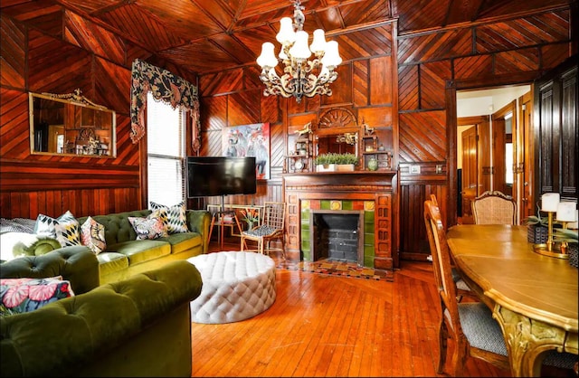 living room featuring a fireplace, wooden walls, a chandelier, wooden ceiling, and hardwood / wood-style flooring
