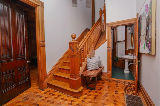 stairway featuring parquet flooring and baseboards