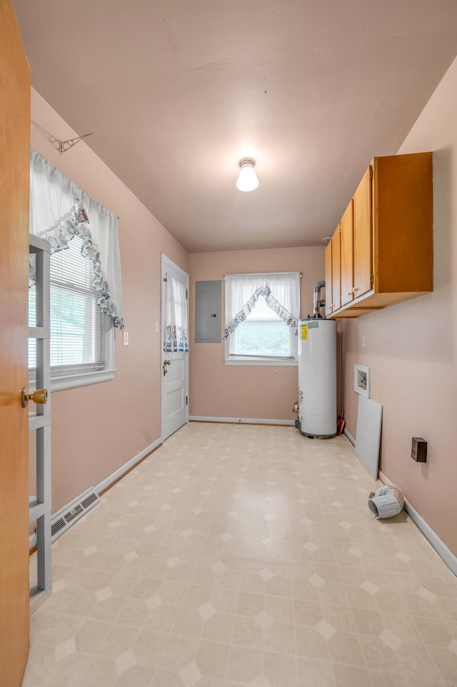 laundry area with electric panel, gas water heater, visible vents, cabinet space, and light floors
