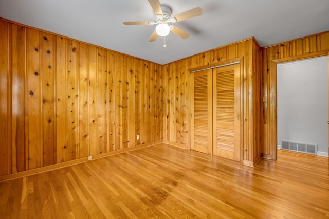 unfurnished bedroom with visible vents, light wood finished floors, baseboards, and a closet