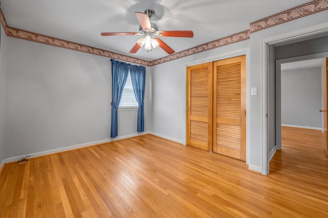 unfurnished bedroom featuring baseboards, light wood-type flooring, ceiling fan, and a closet