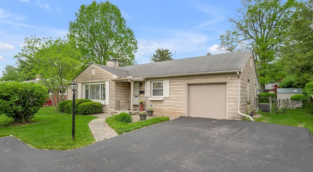 view of front facade featuring fence, a front yard, stone siding, a chimney, and an attached garage