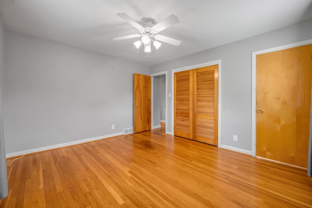 unfurnished bedroom featuring a ceiling fan, visible vents, baseboards, a closet, and light wood-style floors