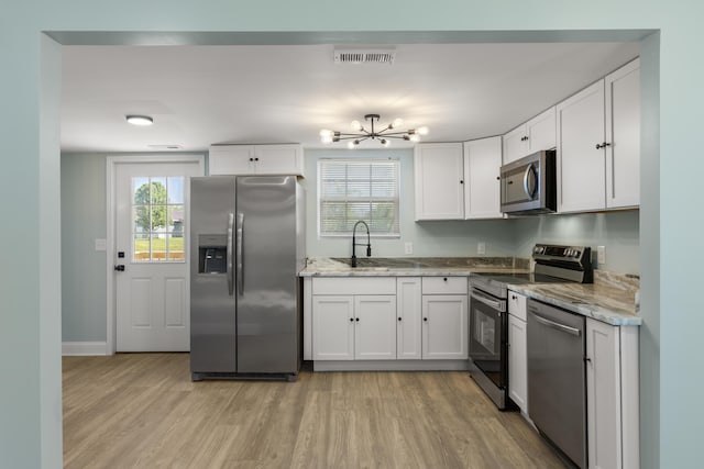 262 Main St, Salt Lick, KY 40371 - kitchen featuring stainless steel appliances, a chandelier, light wood-style flooring, and white cabinetry