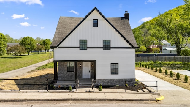 262 Main St, Salt Lick, KY 40371 - view of front facade with a porch, a chimney, a fenced front yard, a shingled roof, and stone siding