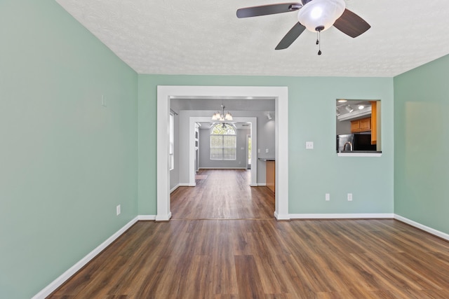 unfurnished room with a textured ceiling, baseboards, and dark wood-type flooring