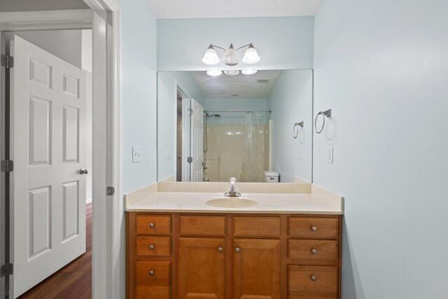 bathroom with vanity, a shower with curtain, and wood finished floors
