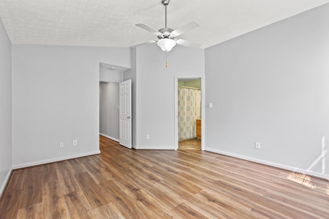 interior space featuring baseboards, a ceiling fan, vaulted ceiling, and wood finished floors