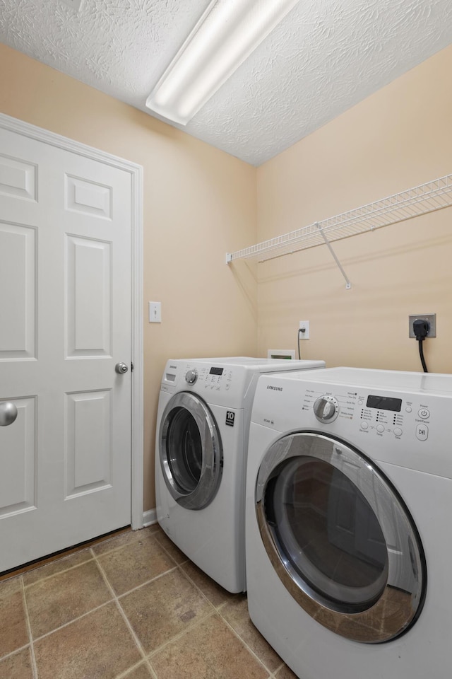 laundry area featuring laundry area, a textured ceiling, and washer and clothes dryer